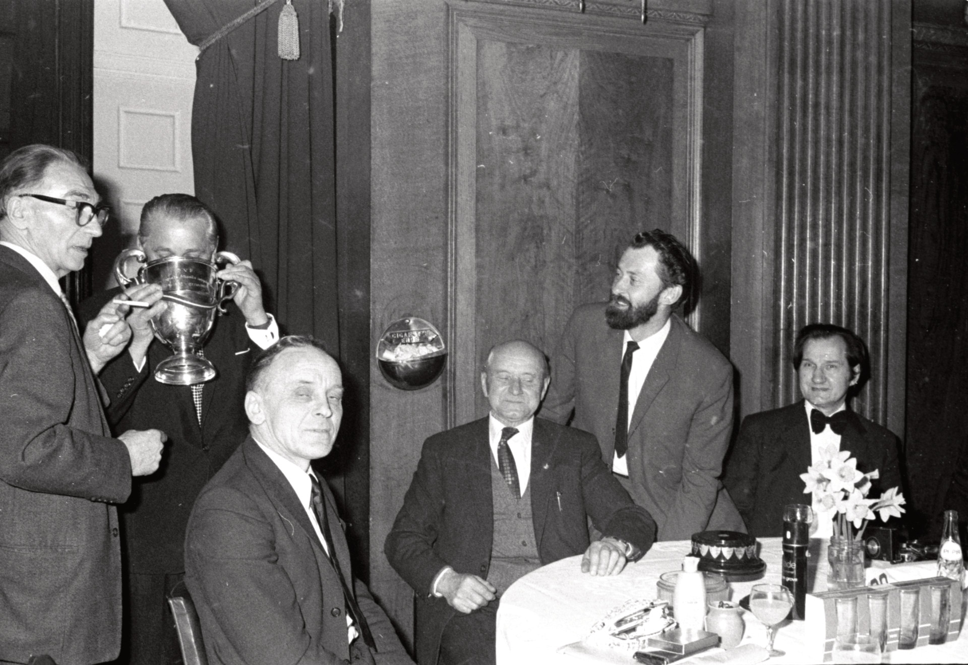 Daugavas Vanagu Lesteres nodaļa - majora Augusta Alksnīša ceļojošā kausa aktīvākajai Daugavas Vanagu nodaļai ieguvēji - Oskara Kalpaka atceres sarīkojumā Porchester Hall, Londonā, 1974. gada 9. martā. No kr. Antons Gailis, nezināms, Aleksandrs Zariņš, Ernests Verģis, Jānis Liepiņš un Pēteris Zariņš.