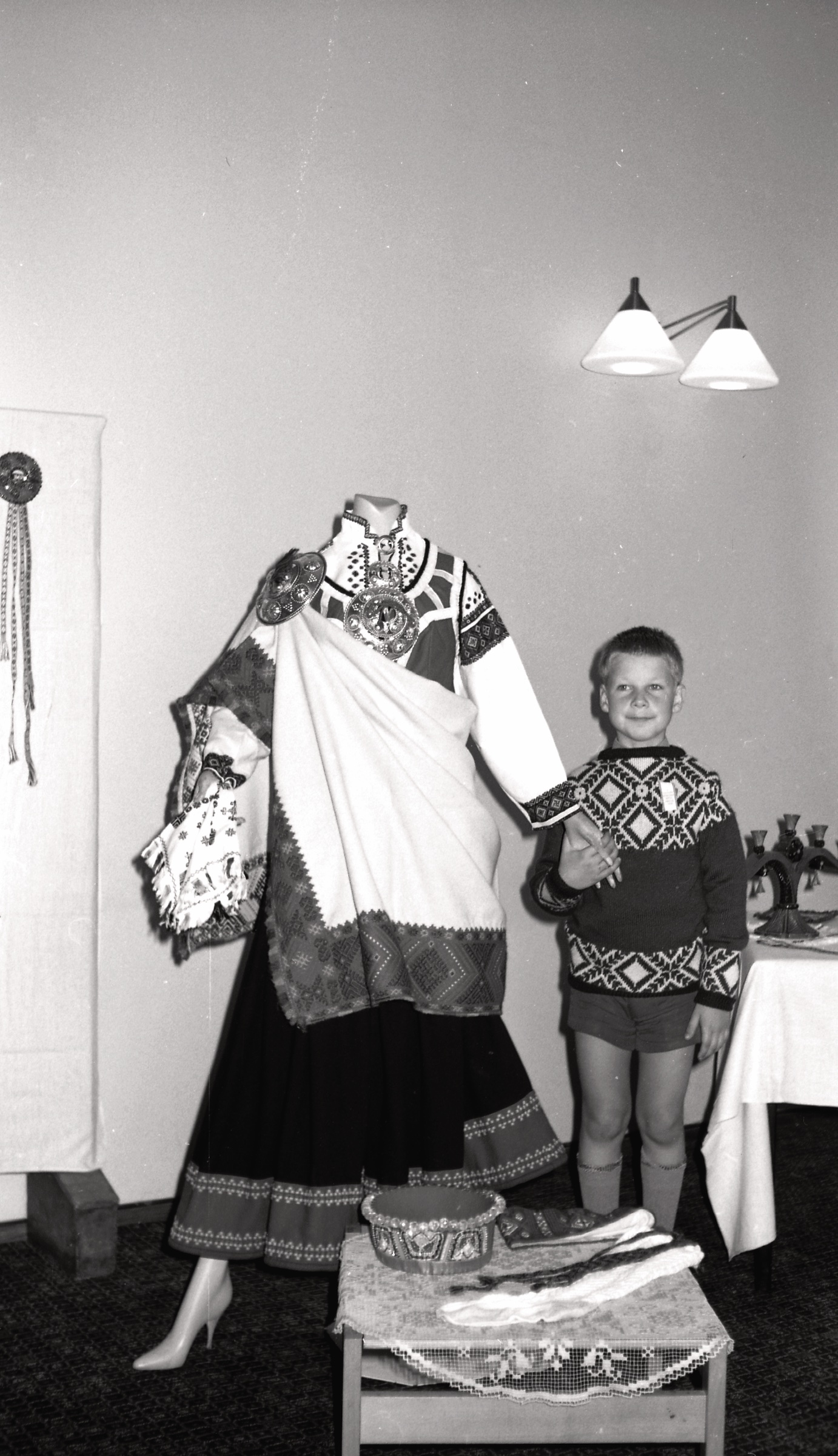 Rolands Blezūrs pie latviešu tautas tērpu izstādes manekena 8. Anglijas latviešu dziesmu dienās Lesterā, 1971. gada 30. jūlijs-1. augusts.