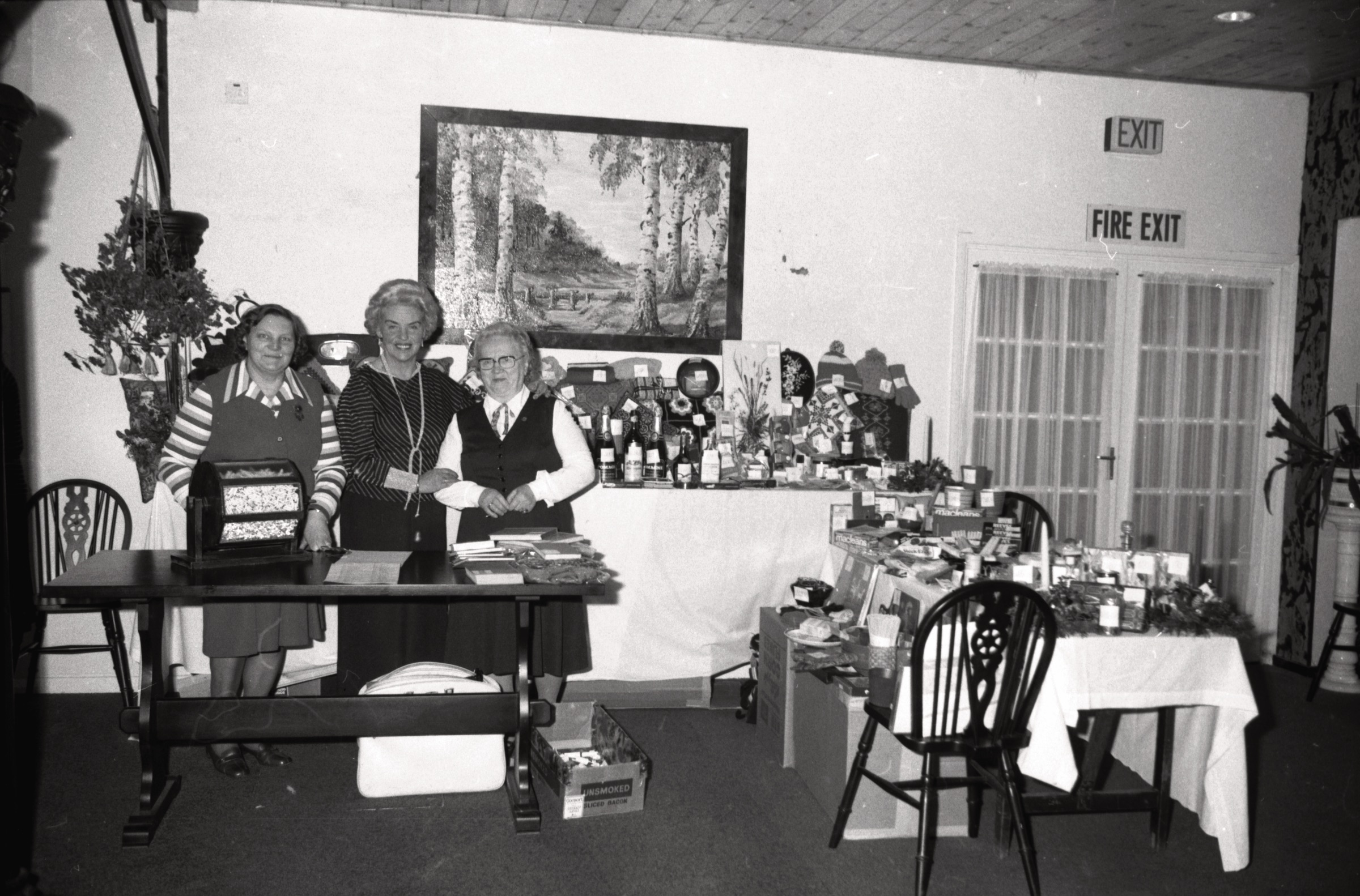 Pie mantu loterijas galda DVF lauku īpašumā 'Straumēni', Catthorpe Manor, Lesteršīra, ap 1976. gadu. No kr. Olga Šulcs, Natālija Miķelsons un Elvīra Čiekurs.