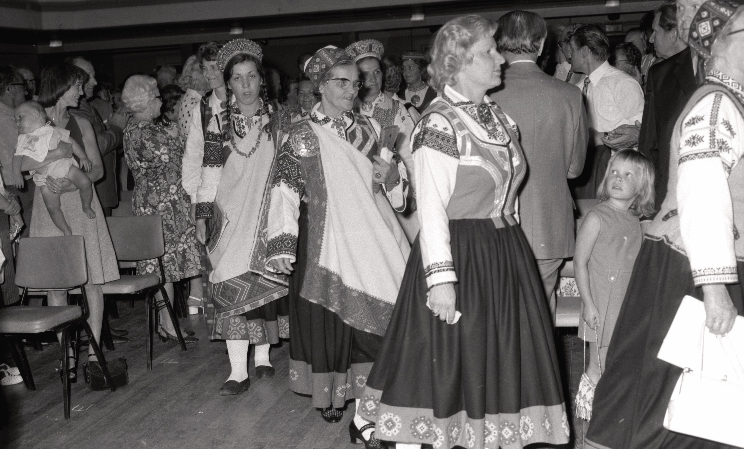 9. Anglijas latviešu dziesmu dienās Lesterā, 1975. gada 1-3. augusts. No labās mazā Andra Frišvalds un tautas tērpos Tamāra Kelka, Herta Karps, Irēne Līcītis, Ducie Ozoliņš. Vidū aizmugurē ar vainagu Vilija Liepa.