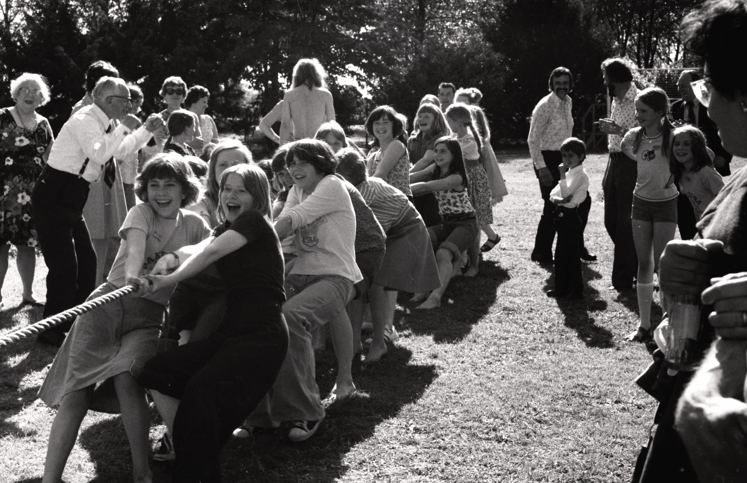 Virves vilkšana Bērnu svētkos DVF Koventrijas nodaļas īpašumā 'Mūsmājas', Volstona, Varvikšīra, 1976. gada 6. jūnijs. Virves vilcējas no kr. Zīle Dreifelde, Rita Harrison, Dzintra Šulcs, Sandra Dambīte. Aizmugurē labā pusē ar ūsām Valdis Auers, viņam priekšā Daunis Auers.