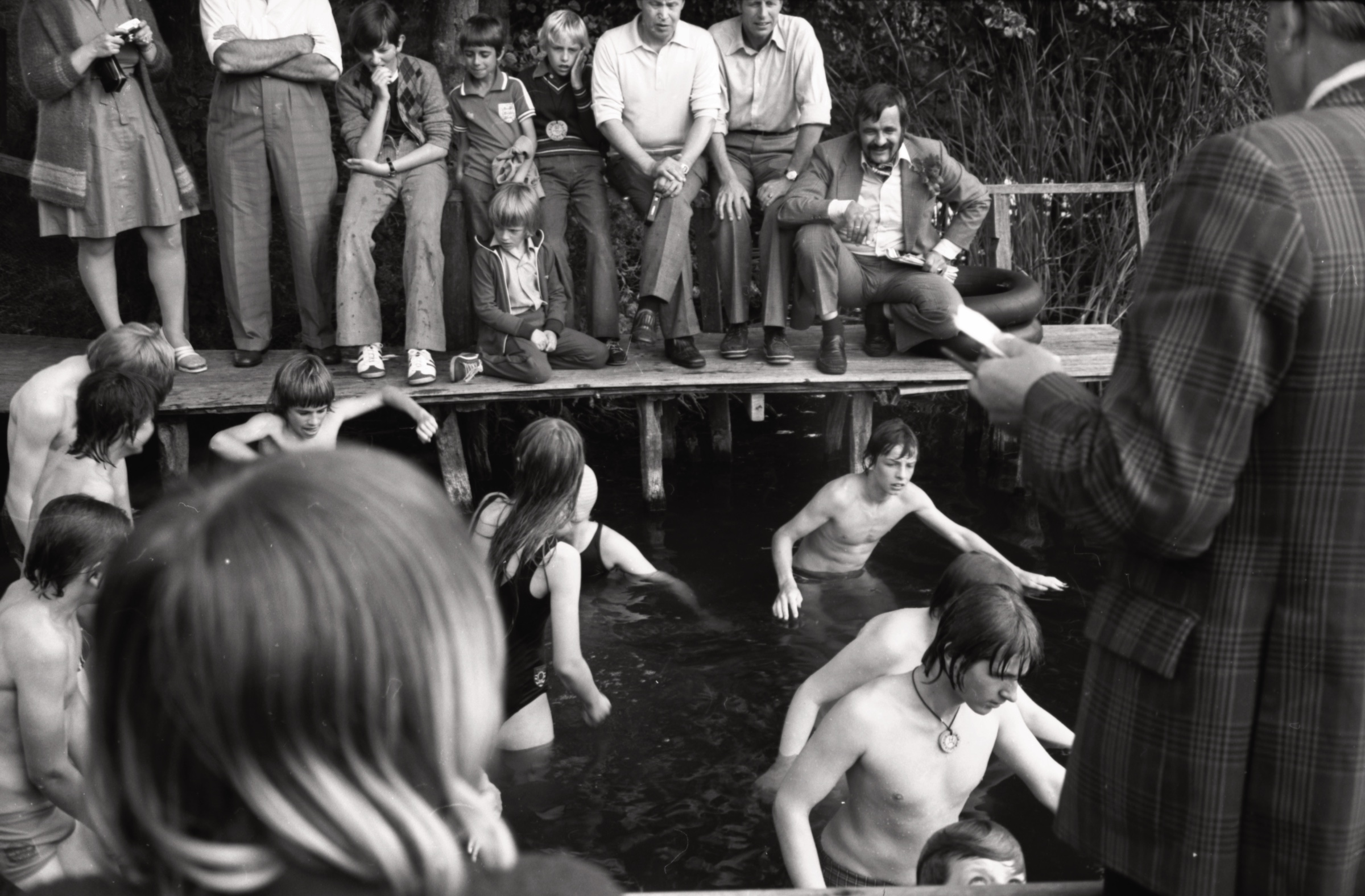 Peldēšanās prieki bērnu nometnes laikā LNPL Latviešu mājā Almelijā, Herefordšīrā, 1978. gads. Uz laipas no kr. Zenta Blezūrs, Jānis Mūrnieks, Kārlis North, Daunis Auers, Kims Ligers, Valdis Avotiņš, Valdis Jostiņš, Valdis Auers un Pauls Muravskis. Ūdenī no labās Valdis Filks, Ēriks Uskalis. Priekšā ar muguru Alfons Freimanis.